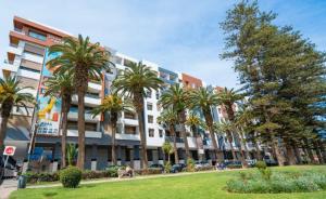 a large building with palm trees in front of it at le joyau de Parc Group A imm B in Mohammedia