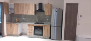 a kitchen with a stainless steel refrigerator and wooden cabinets at le joyau de Parc Group A imm B in Mohammedia