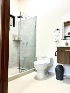 a bathroom with a toilet and a glass shower at Casa Manzu in Nosara +15 photos