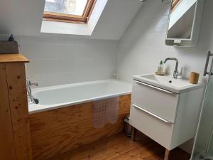 a bathroom with a bath tub and a sink at Ty Jeanne classé 3 étoiles in Ploubazlanec +9 photos