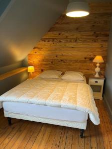 a bedroom with a bed with a wooden wall at Ty Jeanne classé 3 étoiles in Ploubazlanec