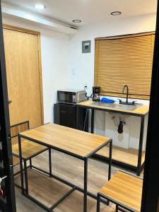 a kitchen with a table and two chairs and a sink at Hotel Playa Los Angeles Bungalow Aloha in Ciudad del Carmen