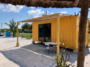 a yellow building with a table and chairs at Hotel Playa Los Angeles Bungalow Aloha in Ciudad del Carmen +2 photos