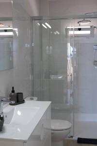 ein weißes Badezimmer mit Dusche und Toilette in der Unterkunft Exclusive & Elegant Luxury Stay with Stunning Ocean Views in San Bartolomé de Tirajana
