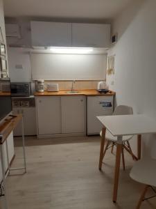 a kitchen with white cabinets and a sink and a table at Cabaña Lo de Mingo in San Antonio de Areco +22 photos