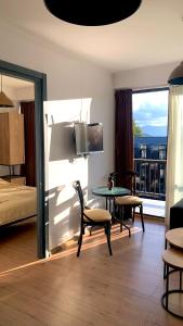 Habitación de hotel con cama, mesa y balcón. en Bakuriani art apart hotel 203, en Bakuriani