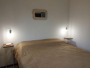a bedroom with a bed with two lights on it at Cabaña Lo de Mingo in San Antonio de Areco