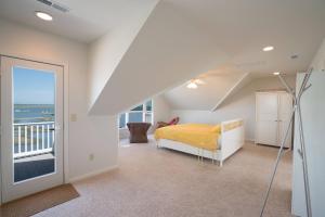 a bedroom with a bed and a balcony at La Vie - Waterfront, boat dock & Pool! in Chincoteague