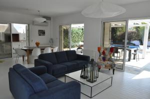 een woonkamer met twee blauwe banken en een tafel bij Katikies 22 in Pissouri