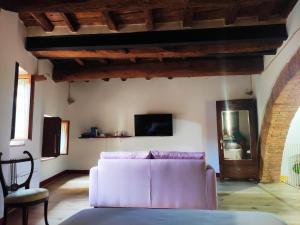 a living room with a white couch and a tv at Antica Dimora Vicolo del Tempio in Spina