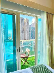 迪拜Stunning 2BR Marina View Apt Close to JBR的一间卧室，配有一张床和一扇带椅子的窗户