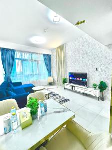 迪拜Stunning 2BR Marina View Apt Close to JBR的客厅里有一张蓝色沙发和一台电视