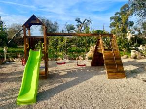 a playground with a green slide and swings at Li Canali Reali in Mesagne