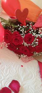 un gâteau avec des roses rouges en haut dans l'établissement SUITE ROMA, à Cefalù