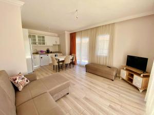 a living room with a couch and a table with a television at Egem House in Datca