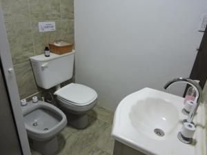 a bathroom with a white toilet and a sink at La Casita de Lucía in Almafuerte