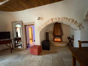 a living room with a stone fireplace in a house at Tipico Suite in Alberobello