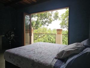 a bedroom with a bed and a large window at Casa de Lux in Ilha de Boipeba