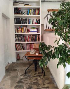 un bureau dans une pièce avec une étagère avec des livres dans l'établissement Les Grands Cyprès - chambres d'hôtes, à Conques-sur-Orbiel