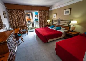 a hotel room with a bed and a balcony at Topaz Hotel in St Paul's Bay