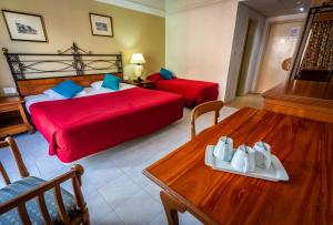 a hotel room with a bed and a table with shoes on it at Topaz Hotel in St Paul's Bay