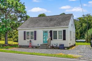 a small white house with a blue door at Lazy Days - Pet friendly with screened gazebo! in Deep Hole