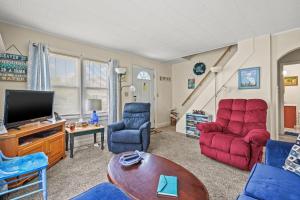 a living room with red chairs and a tv at Lazy Days - Pet friendly with screened gazebo! in Deep Hole