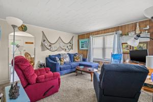 a living room with a blue couch and two chairs at Lazy Days - Pet friendly with screened gazebo! in Deep Hole