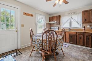 a kitchen with a table and chairs and a ceiling fan at Lazy Days - Pet friendly with screened gazebo! in Deep Hole