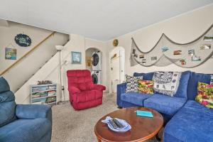 a living room with two blue couches and a table at Lazy Days - Pet friendly with screened gazebo! in Deep Hole