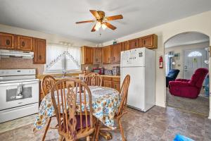 a kitchen with a table and a white refrigerator at Lazy Days - Pet friendly with screened gazebo! in Deep Hole