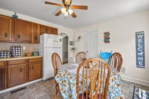a kitchen with a table and a white refrigerator at Lazy Days - Pet friendly with screened gazebo! in Deep Hole