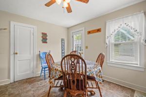 a dining room with a table and chairs and a ceiling fan at Lazy Days - Pet friendly with screened gazebo! in Deep Hole