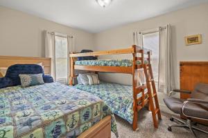 a bedroom with two bunk beds and a chair at Lazy Days - Pet friendly with screened gazebo! in Deep Hole