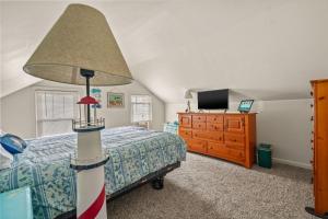 a bedroom with a bed with a lamp and a dresser at Lazy Days - Pet friendly with screened gazebo! in Deep Hole