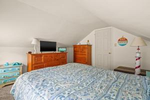 a bedroom with a bed and a dresser and a tv at Lazy Days - Pet friendly with screened gazebo! in Deep Hole