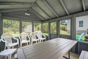 a screened in porch with a wooden table and chairs at Lazy Days - Pet friendly with screened gazebo! in Deep Hole
