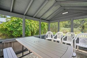 a table and chairs on a screened porch with windows at Lazy Days - Pet friendly with screened gazebo! in Deep Hole