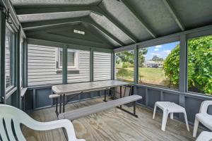 a screened porch with a picnic table and benches at Lazy Days - Pet friendly with screened gazebo! in Deep Hole