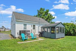 a small house with two chairs and a gazebo at Lazy Days - Pet friendly with screened gazebo! in Deep Hole