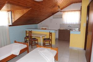 a room with two beds and a table and a kitchen at Isavella Studios in Amoudi