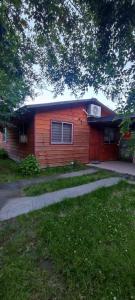 a small red house with a tree in front of it at cabaña de 1 piso in Coñaripe