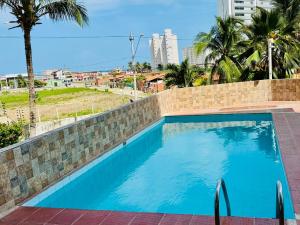 een zwembad in een bakstenen muur met blauw water bij Vista mar, piscina, na praia do futuro, com Ar condicionado e Wi-Fi in Fortaleza