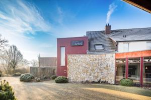 un edificio rosso con un muro in pietra di Balland's Hotel & Restaurant a Lindwedel