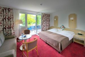 a hotel room with a bed and a living room at Seehotel Ichlim in Lärz