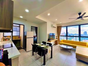 un salon avec un canapé jaune et une table dans l'établissement Comfortable 2BR 5 Queen Beds, Netflix & Free Parking, à Jelutong