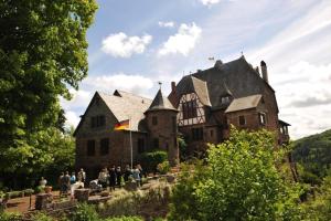 un groupe de personnes debout devant un bâtiment dans l'établissement Haus Budinger, à Alf 5 autres photos