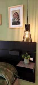 Un dormitorio con una planta en maceta sobre una mesa con una lámpara. en Freistehendes Zwei Zimmer Haus, en Peschici