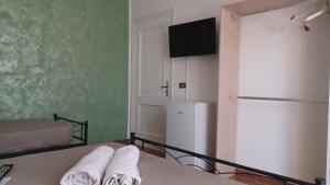 a room with a refrigerator and a bed with towels at B&B home vintage in Marconia