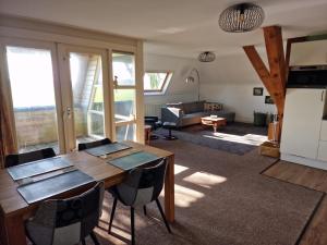 a living room with a wooden table and chairs at Tussen Wad en Dijk - Vakantieappartement in Sint Jacobiparochie